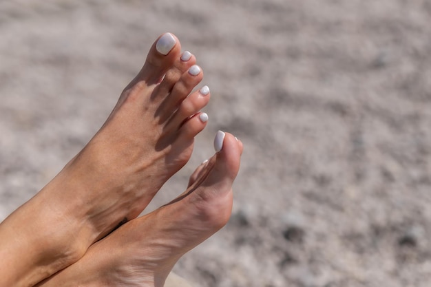 Młoda kobieta opalając się na leżaku. Nogi na leżaku na plaży, sielankowe wakacje lub koncepcja wakacje transparent na niewyraźne tło. Letnie wibracje w tle