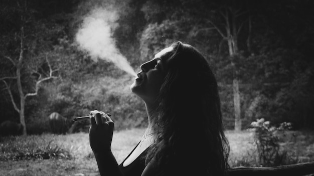 Zdjęcie młoda kobieta paląca marihuanę na boisku.