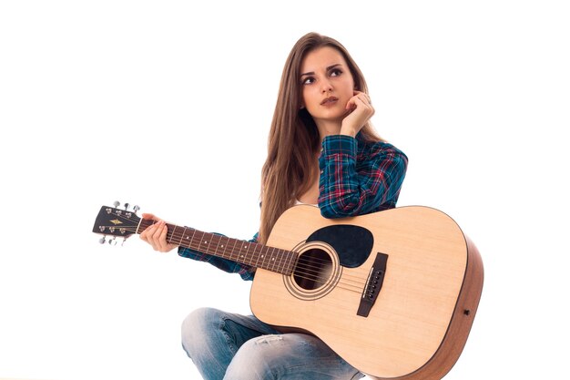 Młoda kobieta, patrząc od hotelu z gitarą