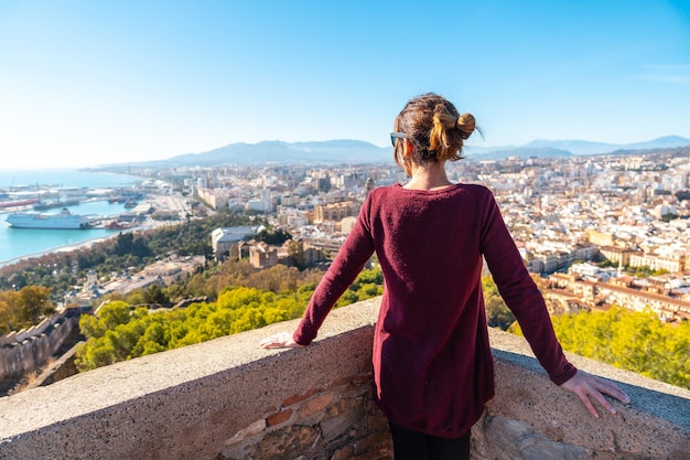 Młoda kobieta patrząca na miasto z muru zamku Gibralfaro w mieście Malaga, Andaluzja. Hiszpania