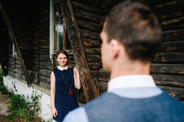 Zdjęcie młoda kobieta patrzy na swojego męża stojącego w pobliżu starego drewnianego, stylowego domu