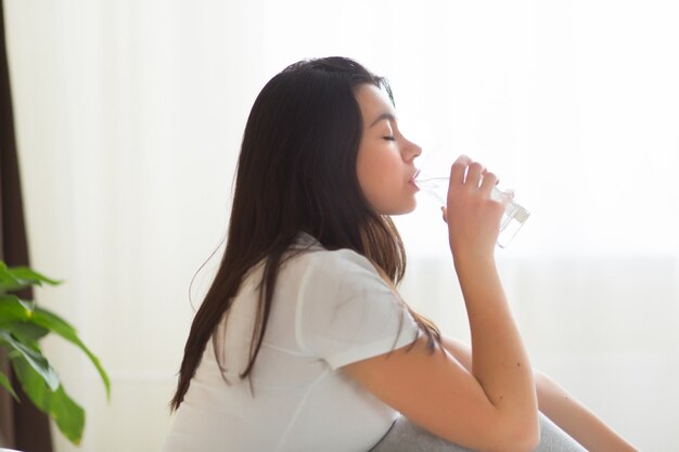 Młoda kobieta pić szklankę wody rano, koncepcja zdrowego stylu życia