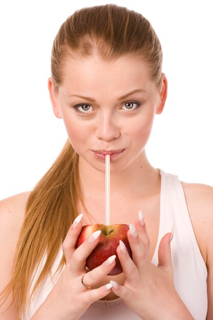 młoda kobieta pijąca sok z połowy jabłka