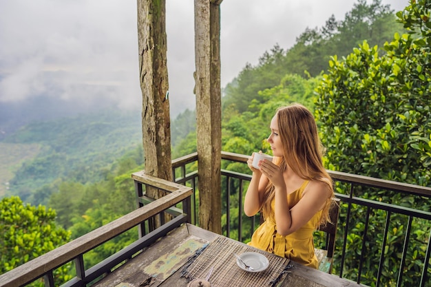 Młoda kobieta pije kawę w kawiarni w górach