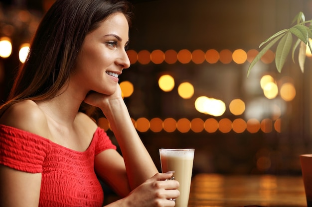 młoda kobieta pije kawę w kawiarni