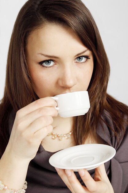 Zdjęcie młoda kobieta pije kawę z filiżanki