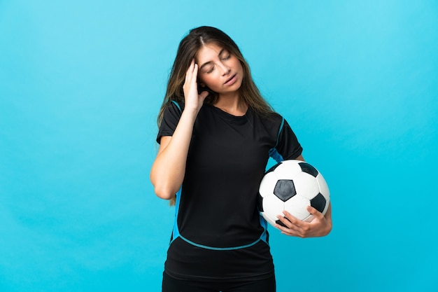 Młoda kobieta piłkarz na białym tle na niebieskiej ścianie z bólem głowy