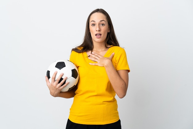 Młoda kobieta piłkarz na białym tle zaskoczona i zszokowana, patrząc w prawo