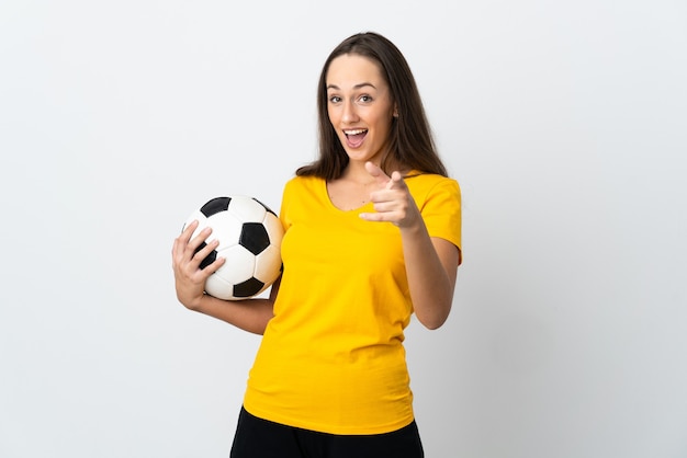 Młoda kobieta piłkarz na białym tle zaskoczony i wskazujący przód