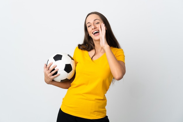Młoda kobieta piłkarz na pojedyncze białe ściany krzycząc z szeroko otwartymi ustami