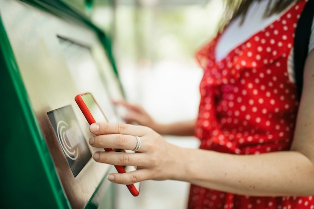 Młoda kobieta płaci za pomocą aplikacji na telefon komórkowy za transport publiczny Koncepcja podróży i dojazdów