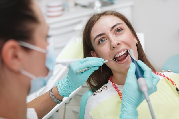 Młoda kobieta po leczeniu stomatologicznym przez profesjonalnego dentystę