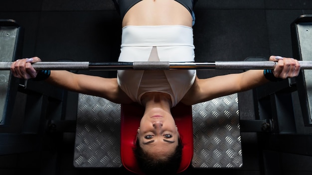 Zdjęcie młoda kobieta podczas ćwiczeń na ławce w siłowni