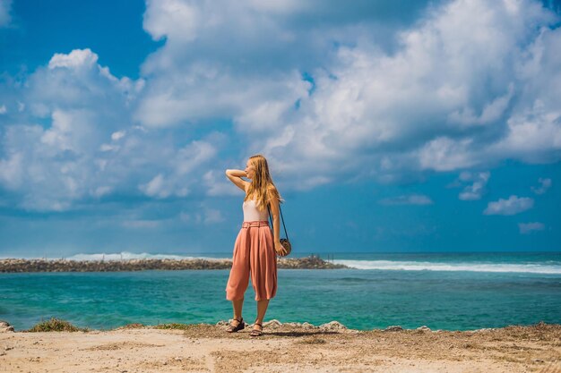 Młoda kobieta podróżniczka na niesamowitej plaży Melasti z turkusową wodą, wyspa Bali, Indonezja