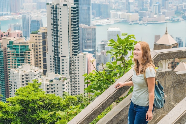 Zdjęcie młoda kobieta podróżniczka na szczycie wiktorii na tle hongkongu