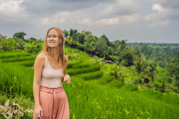 Młoda kobieta podróżnik na piękne tarasy ryżowe Jatiluwih na tle słynnych wulkanów na Bali, Indonezja.