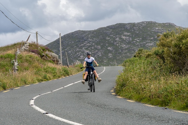 Młoda kobieta podróżnik rowerzysta uśmiechający się na trasie Connemara Galway Irlandia