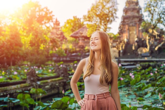 Młoda kobieta podróżnik w tle świątyni Pura Taman Kemuda Saraswati w Ubud, wyspa Bali, Indonezja ze światłem słonecznym