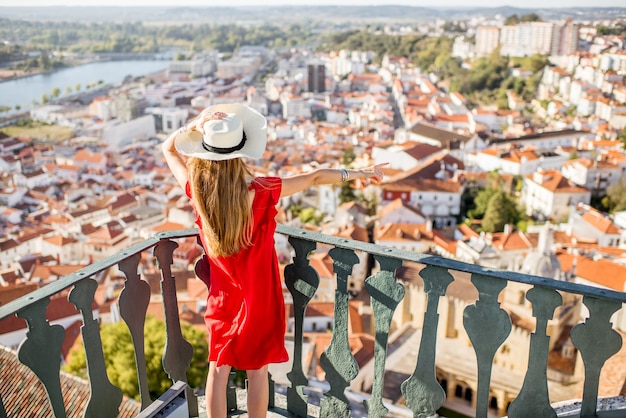 Młoda kobieta podziwiająca widok z lotu ptaka na stare miasto Coimbra podczas zachodu słońca w środkowej Portugalii