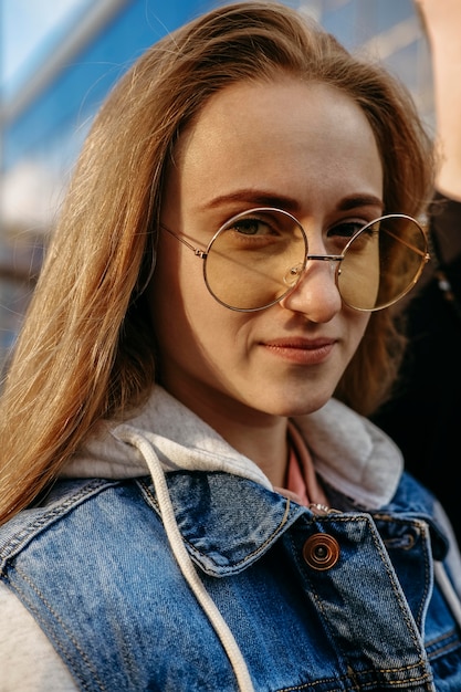 Zdjęcie młoda kobieta pozuje mając na sobie okulary przeciwsłoneczne