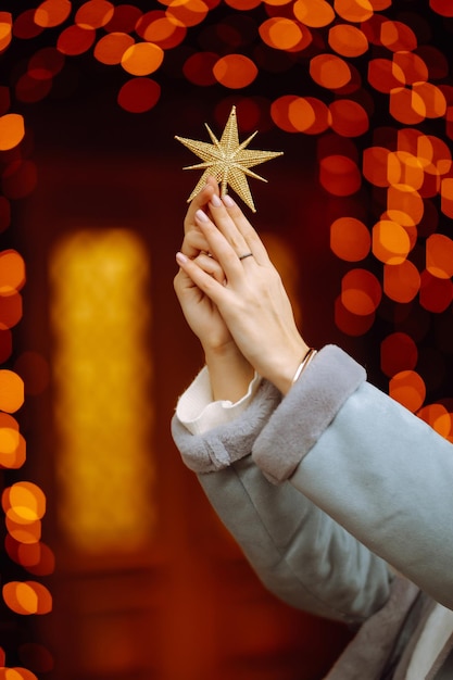 Młoda kobieta pozuje przy choince podczas ferii zimowych z bożonarodzeniową gwiazdą