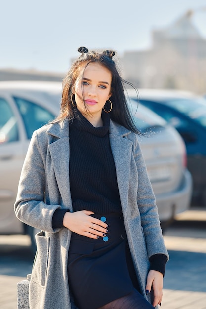 Młoda kobieta pozuje w pobliżu parkingu w pobliżu centrum handlowego