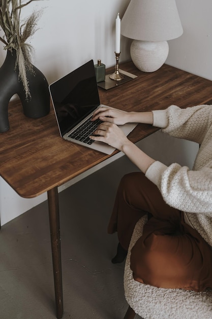 Młoda kobieta pracująca na laptopie siedząca na drewnianym stole Praca w domu koncepcja freelancera Estetyczna dziewczyna szefowa dama szefowa biznesu Branding blog sklep media społecznościowe Zakupy online