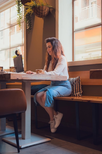 Młoda kobieta pracująca w restauracji z laptopem