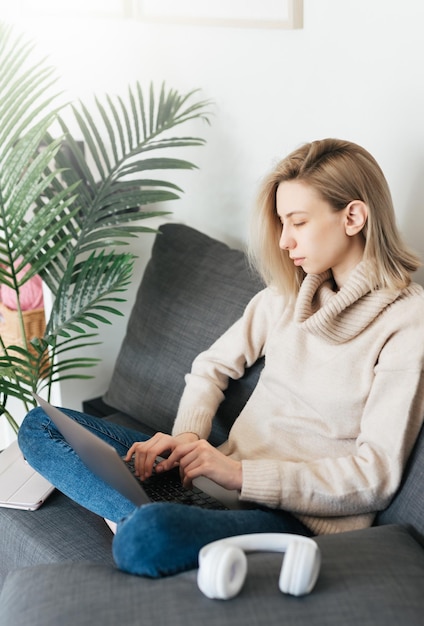 Zdjęcie młoda kobieta pracuje nad laptopem w domu.