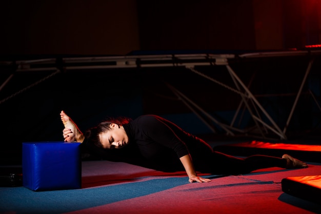 Młoda Kobieta Praktykuje Siedzenie Sznurka. Sportowa Dziewczyna Robi Gimnastykę Na Siłowni. Aktywny Styl życia