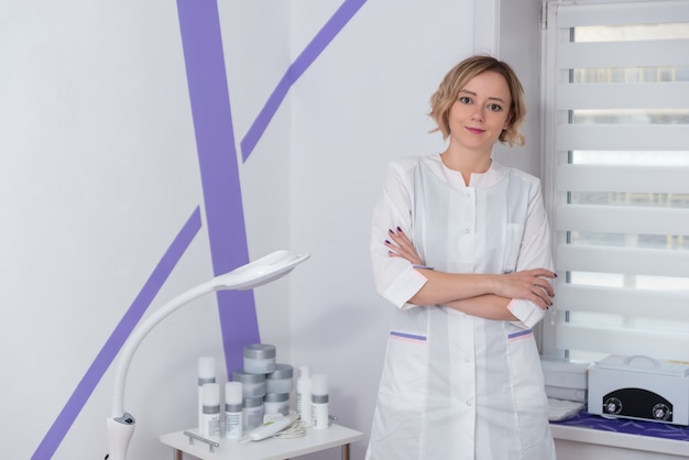 Zdjęcie młoda kobieta profesjonalna lekarka patrzy bezpośrednio w kamerę kosmetologów w salonie kosmetycznym