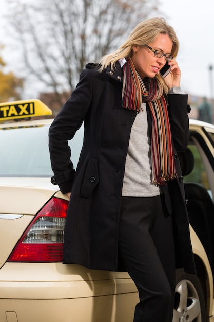 Młoda Kobieta Przed Taxi Z Telefonem