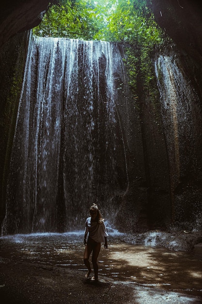 młoda kobieta przy wodospadzie w skale Bali Indonezja