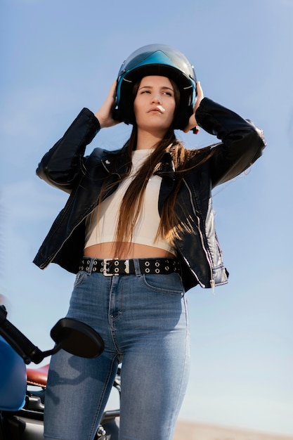 Zdjęcie młoda kobieta przygotowuje się do jazdy motocyklem w mieście