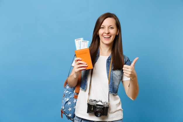 Młoda Kobieta Radosna Studentka Z Retro Vintage Aparat Fotograficzny Na Szyi Trzymać Paszport, Bilety Na Pokład Wyświetlono Kciuk Na Białym Tle Na Niebieskim Tle. Kształcenie Na Uniwersytecie Za Granicą. Lot W Podróży Lotniczej.