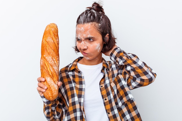 Młoda kobieta rasy mieszanej Dokonywanie chleba na białym tle na białej ścianie dotykając tyłu głowy, myśląc i dokonując wyboru.