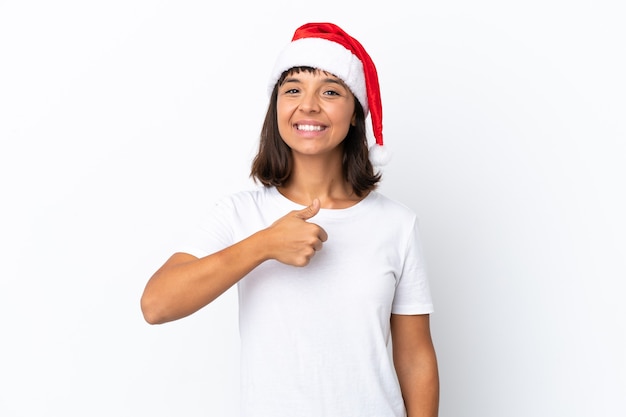 Młoda kobieta rasy mieszanej świętuje Boże Narodzenie na białym tle dając kciuk w górę gest