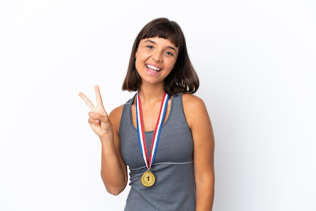Młoda Kobieta Rasy Mieszanej Z Medalami Na Białym Tle Uśmiechnięta I Pokazująca Znak Zwycięstwa