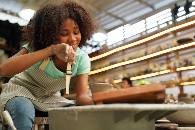Młoda kobieta ręcznie garncarz robi gliniany wazon w warsztacie garncarskim Właściciel firmy