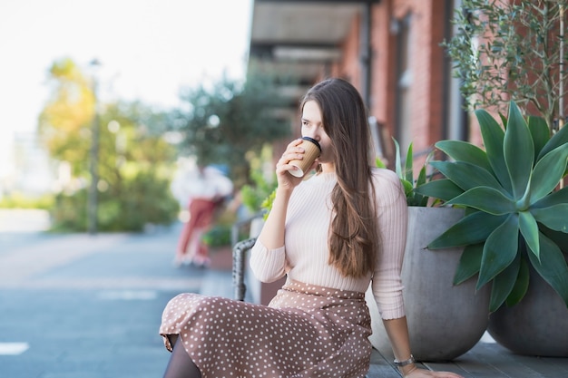 Młoda kobieta relaks z filiżanką kawy w dłoni