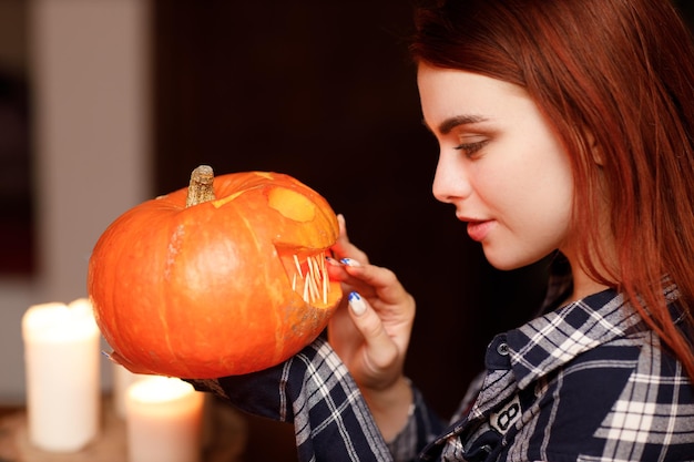 Młoda kobieta robi Halloween dynia Jackolantern Kobiece ręce kroją dynie nożem