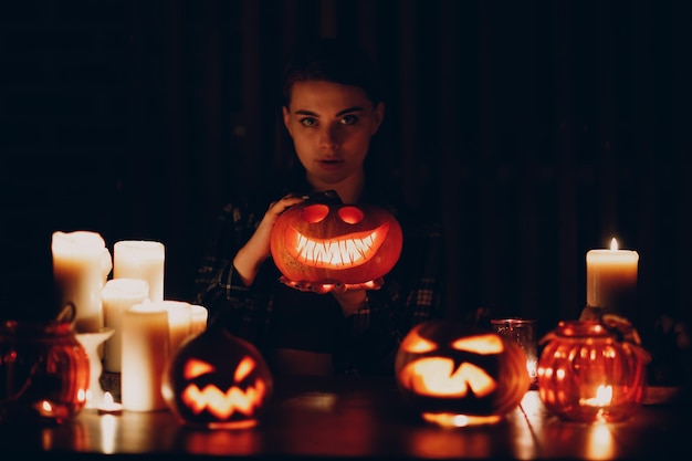 Młoda kobieta robi Halloween dynia Jackolantern Kobiece ręce kroją dynie nożem