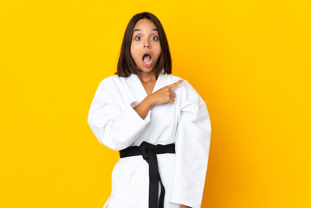 Młoda kobieta robi karate na białym tle