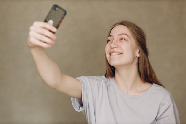 Młoda Kobieta Robi Selfie Telefon Komórkowy Przy Brown Tłem