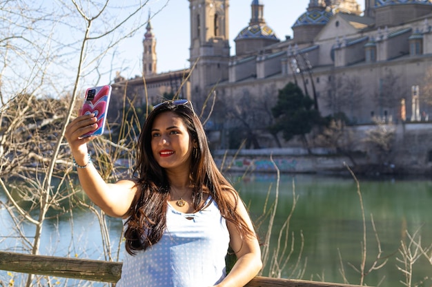 Młoda kobieta robi sobie selfie obok katedry Pilar