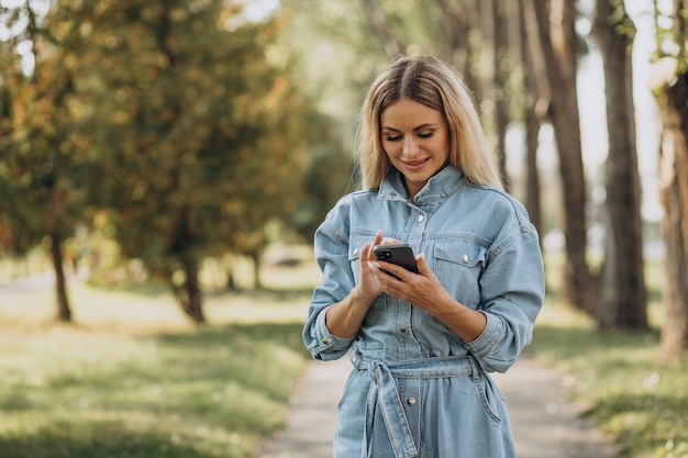 Młoda kobieta robi zakupy online w parku