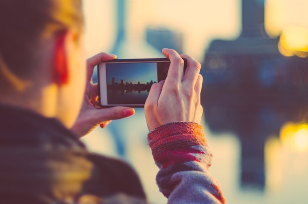 Młoda kobieta robi zdjęcia miasta smartfonem