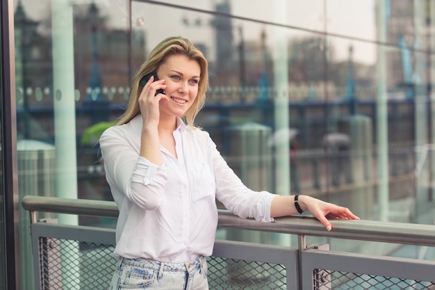 Młoda kobieta rozmawia przez telefon komórkowy