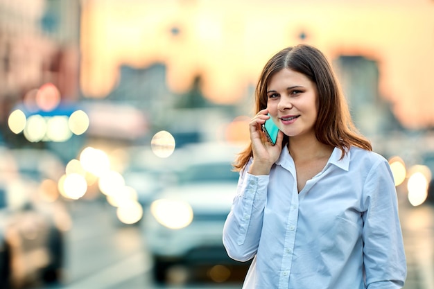 Młoda Kobieta Rozmawia Przez Telefon Na Ulicy W Letni Wieczór