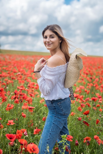 Młoda kobieta sama na mak w letni dzień pola